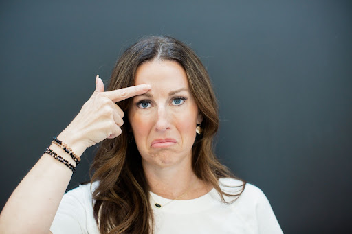 Woman pointing at frown lines